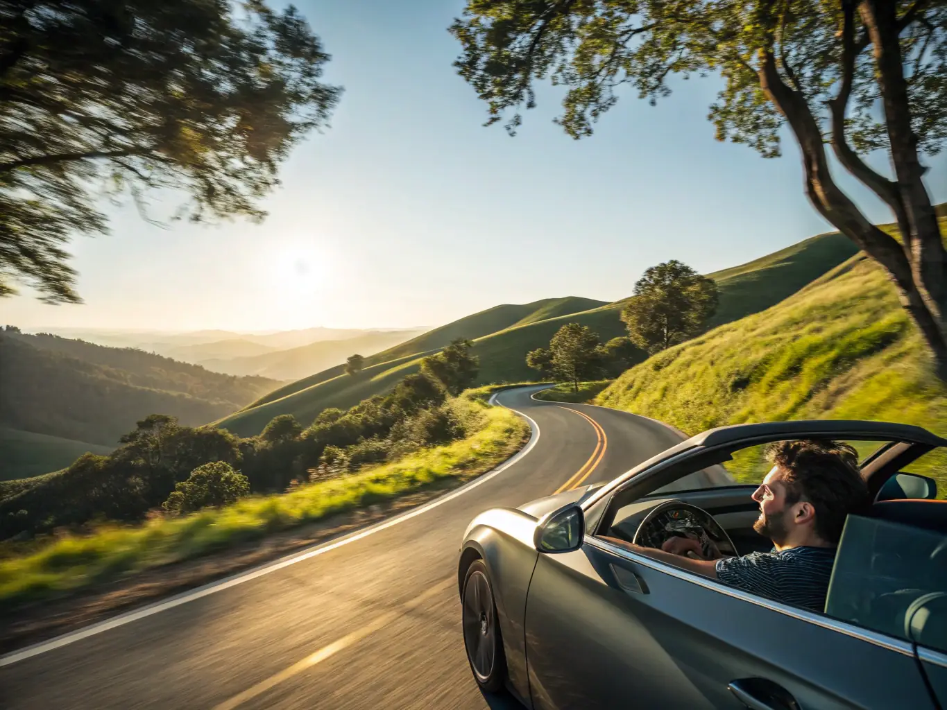 A modern car driving on a scenic open road under a clear blue sky, representing the freedom and safety provided by RiskShield's auto insurance.